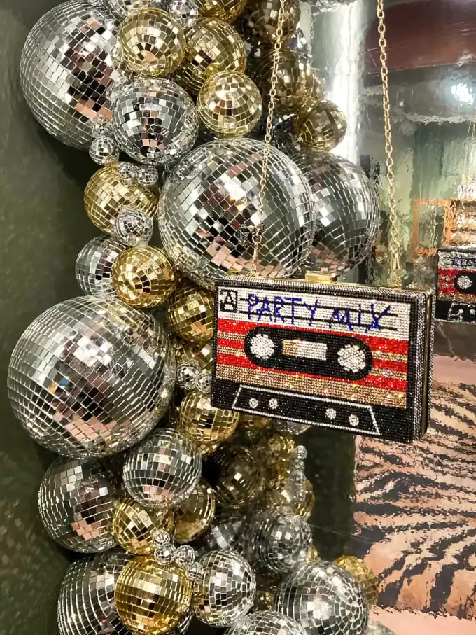 Festdekoration med glitrende disco-kugler i guld og sølv, samt en retro kassettebånds taske.
