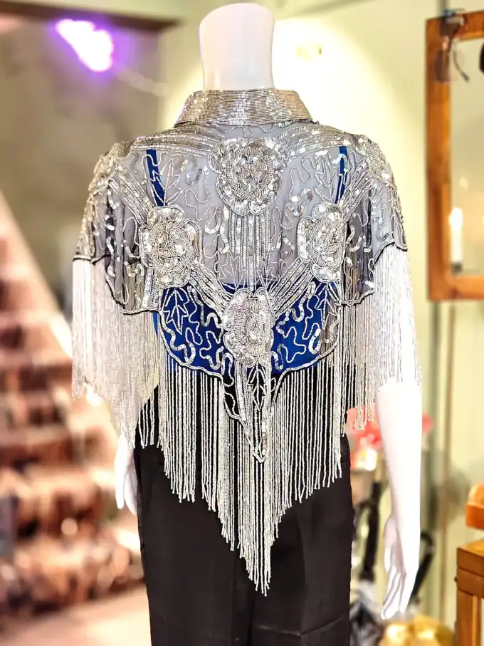 Perlekappe i sølv med elegante frynser og detaljer, perfekt til festlige anledninger.