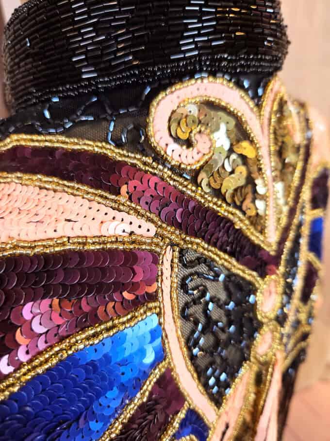 Håndbroderet kappe i sort med koral sommerfugl, perler og sorte frynser - detaljer