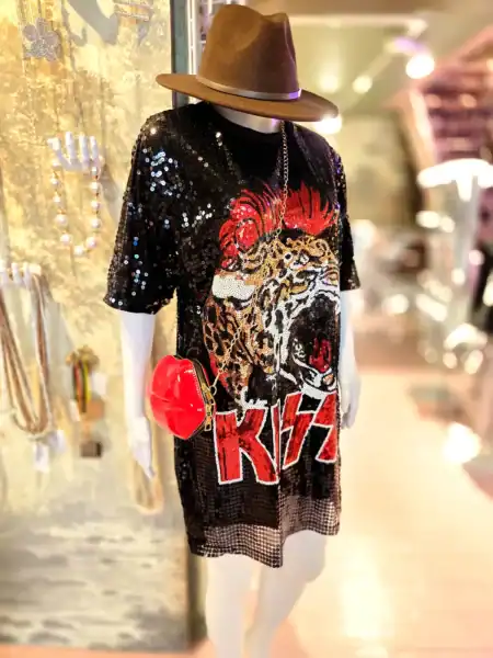 Modestil med paillettrøje, hat og rød clutch i butik.