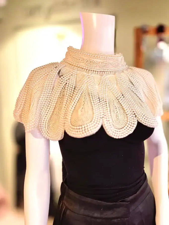 Perlekappe i hvide perler uden frynser, perfekt til elegante outfits og accessories.
