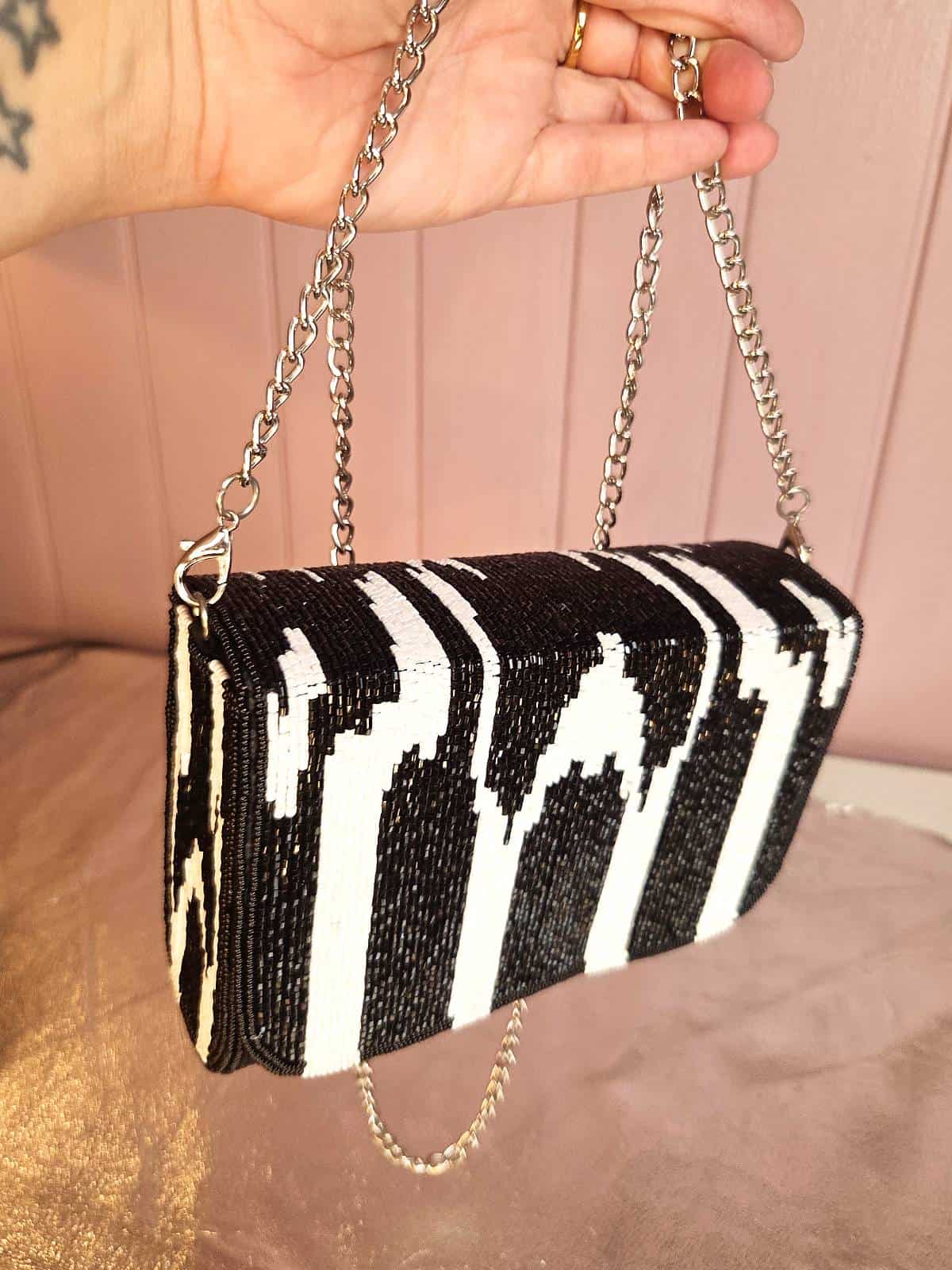 zebra perleclutch holdt i hånd