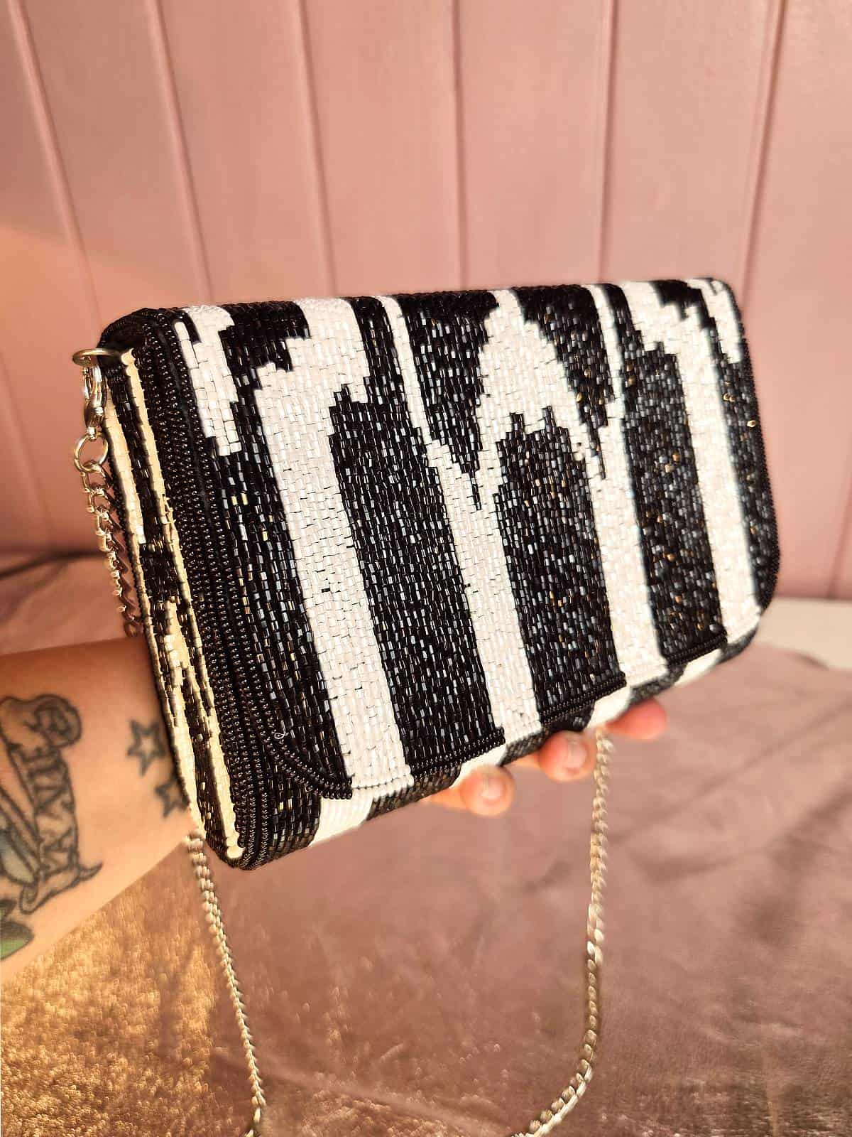 zebra perleclutch holdt i hånden