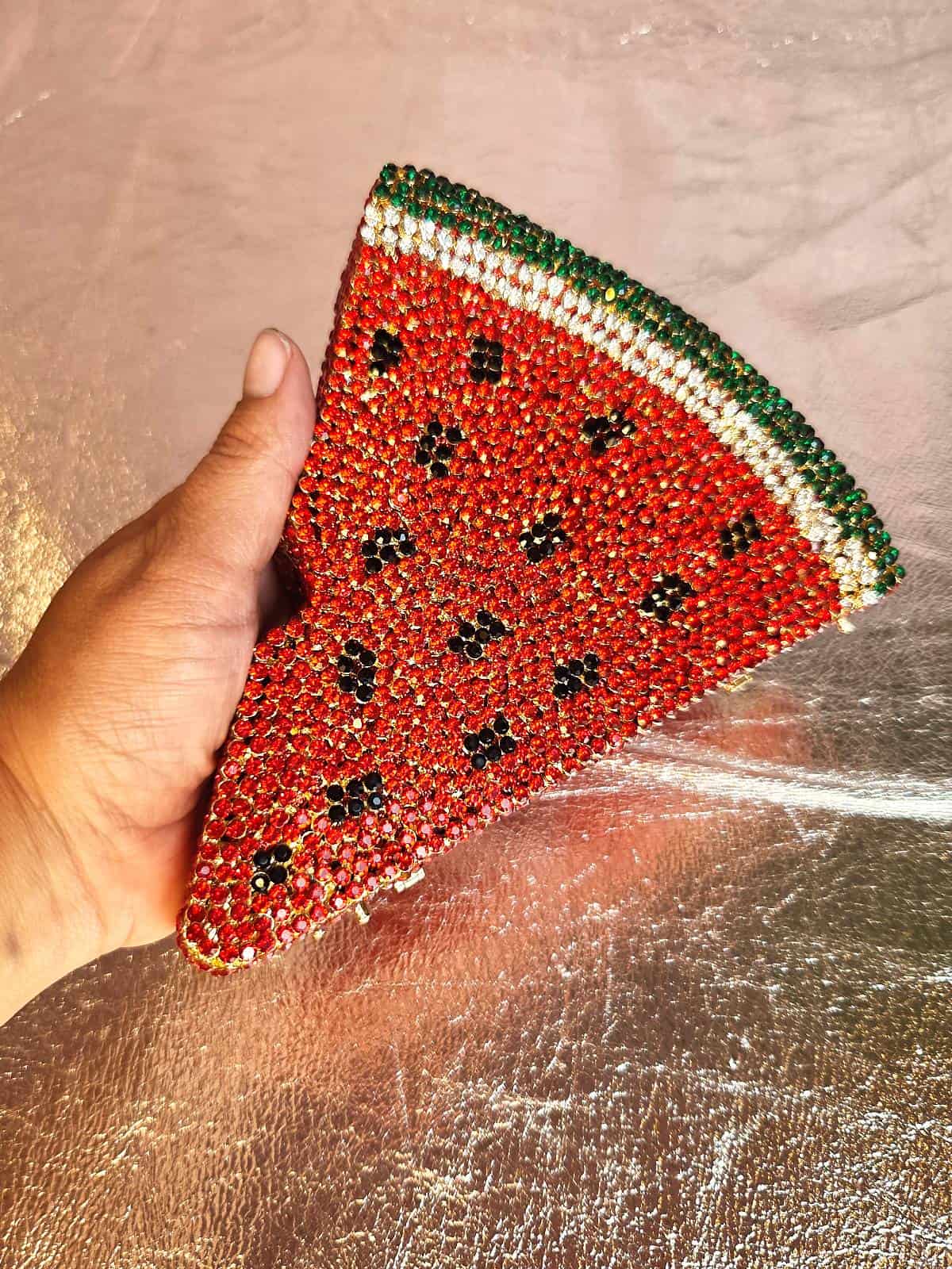 clutch med similisten formet som vandmelon holdt i hånd