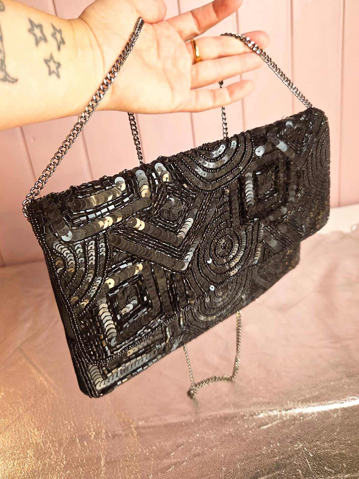 håndlavet clutch med perler sort hængende i hånd