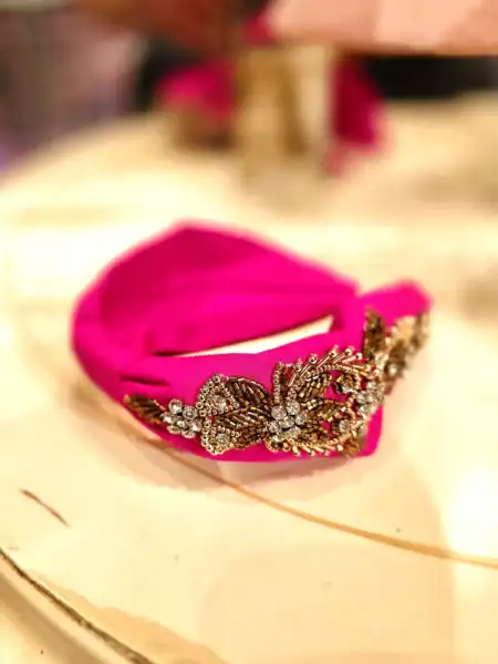 Håndlavet pink hårbøjle med guldperler, perfekt til styling og accessories.