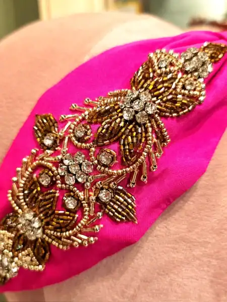 Håndlavet pink hårbøjle med guldperler og rhinestones, perfekt til festlige anledninger.