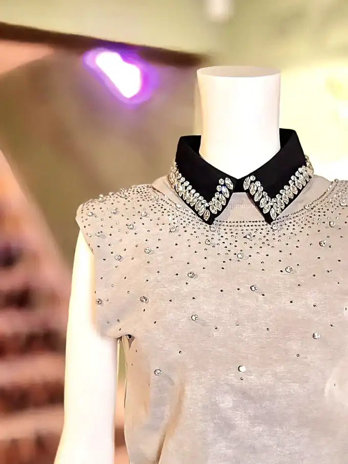 Hvid krave med similisten detaljer og sort kant, perfekt til elegante outfits.