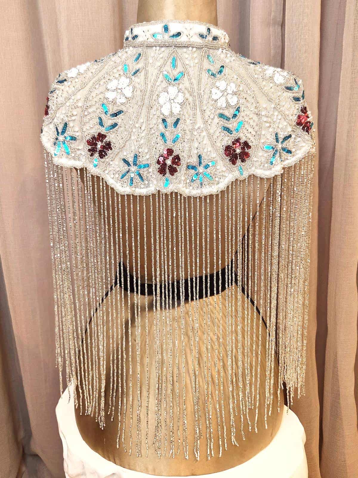 perlekappe hvid med blå og lilla blomster - ryg