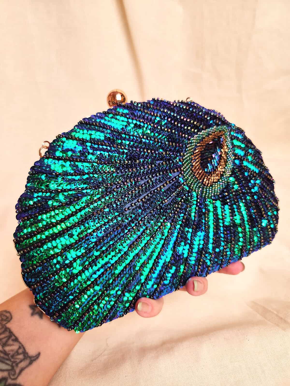 perleclutch påfugl i hånd