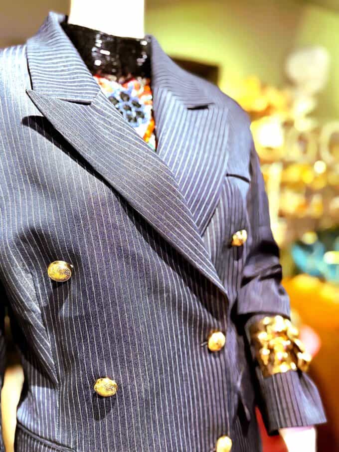 Nålestribet blazer i klassisk design med guldknapper, perfekt til formelle og festlige anledninger.