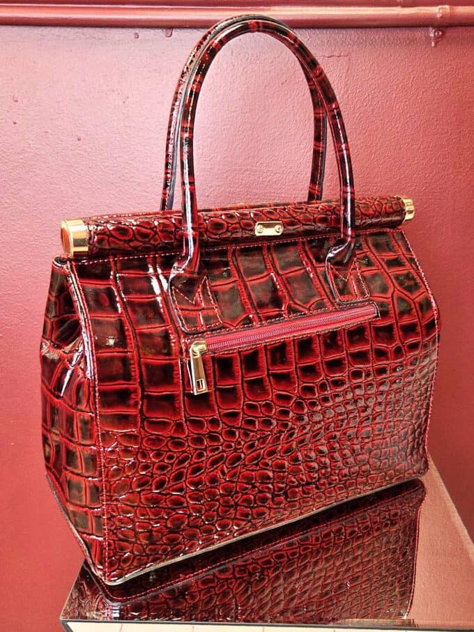 Croco-lædertaske i cognac med guldfarvede detaljer.