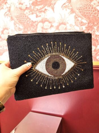 Evil Eye clutch i sort med orange detaljer og øje-design, perfekt til tilbehør og beskyttelse.