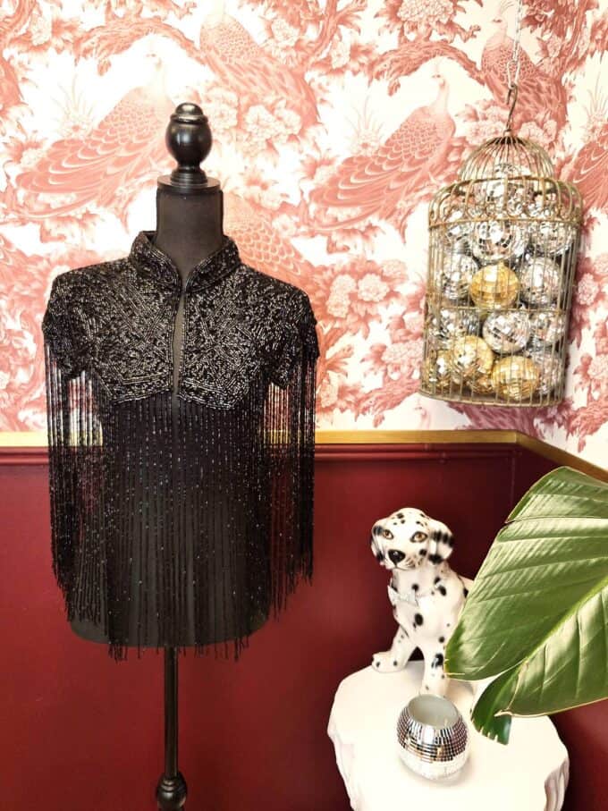 Elegant sort zigzag perlekappe med frynser, perfekt til festlige anledninger.