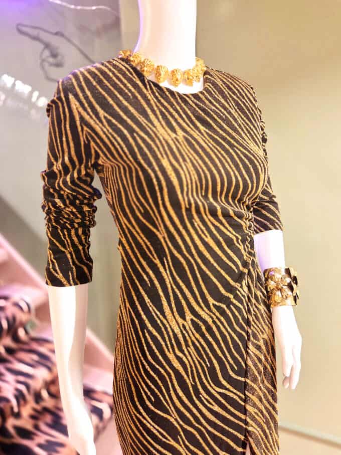 Guldglitrende kjole med zebra-striber, cut-out detalje og lange ærmer. Perfekt til festlige lejlighe.