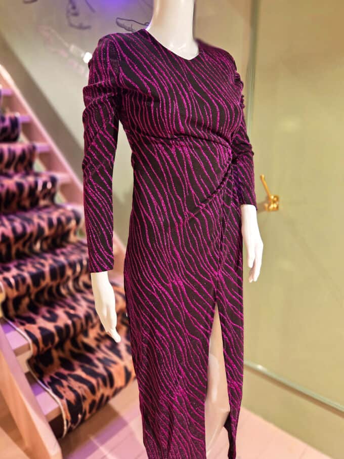Glimmerstribet kjole med cut-out detalje i lilla, perfekt til festlige lejligheder.
