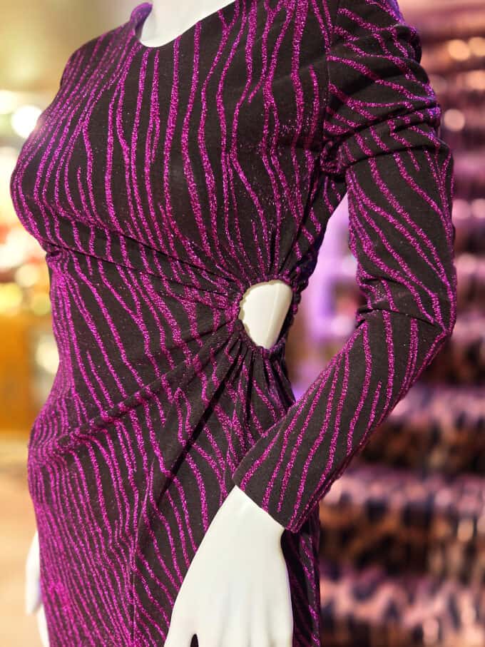 Glimmerstribet kjole med cut-out detalje i lilla, perfekt til festlige lejligheder.