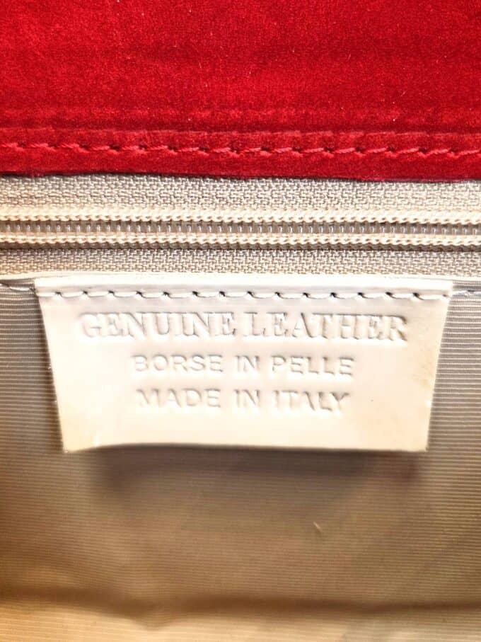 Elegant læderclutch med bambushank i cremefarvet design.