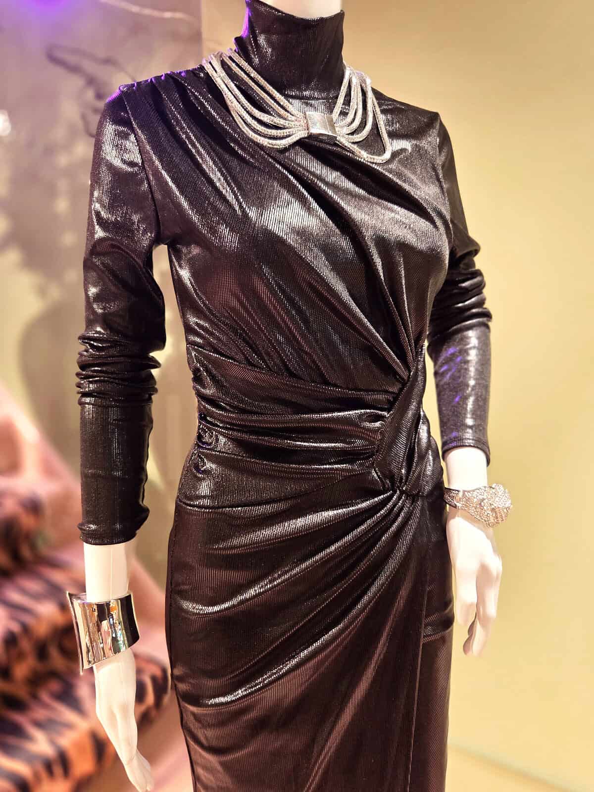 Metallic wrap kjole i sort med slids og elegant design.