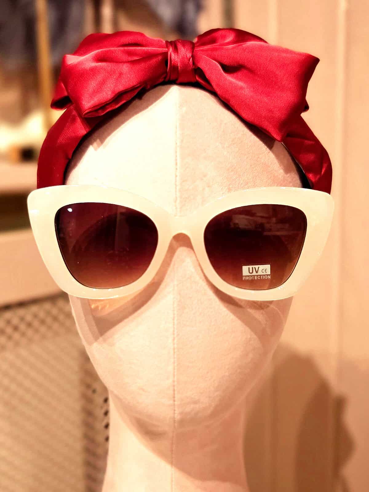 Solbriller med stor hvid ramme og mørke linser, perfekt til solrige dage.