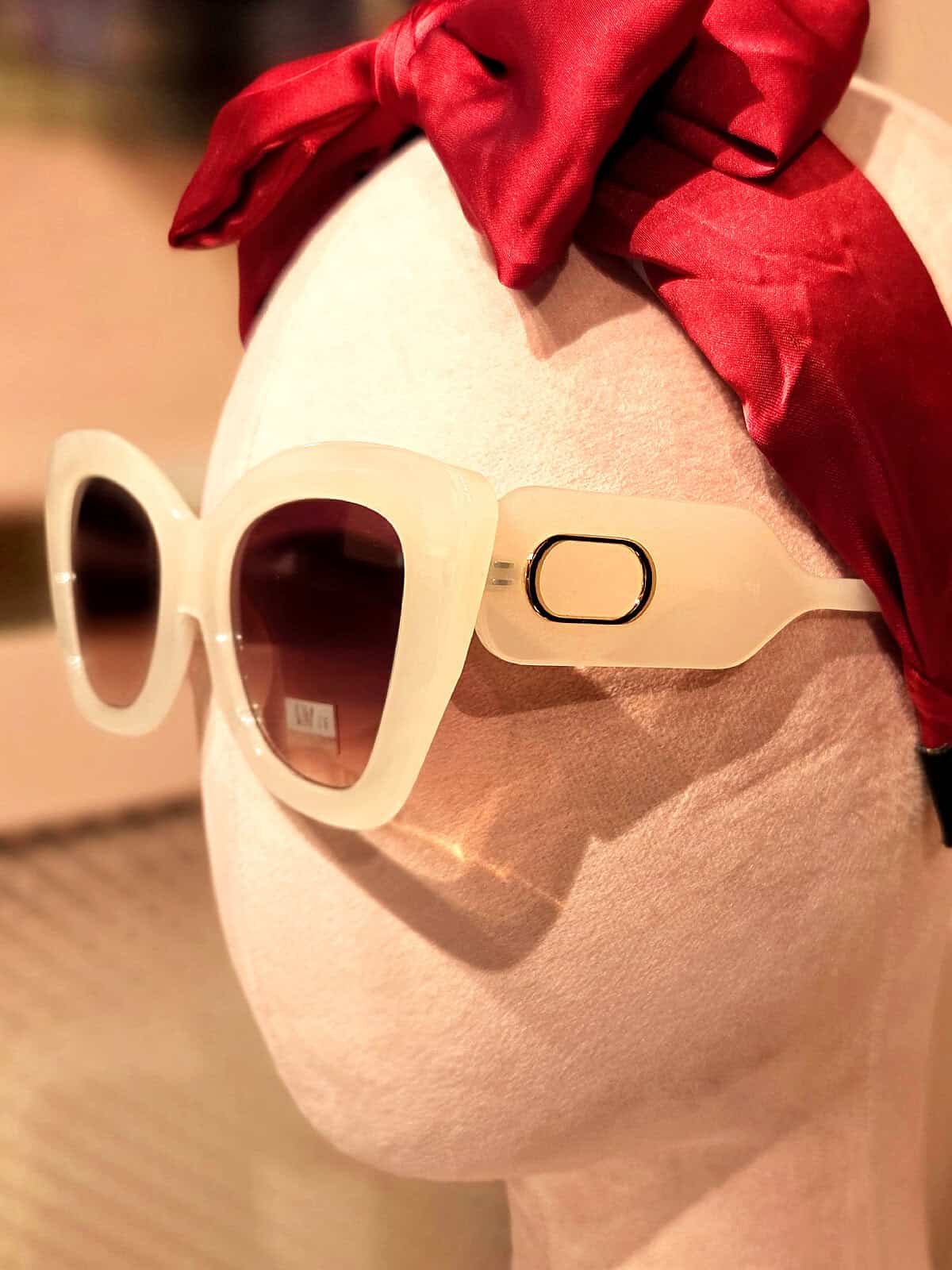 Solbriller med beige ramme og mørke linser, perfekt til sommer og solrige dage.