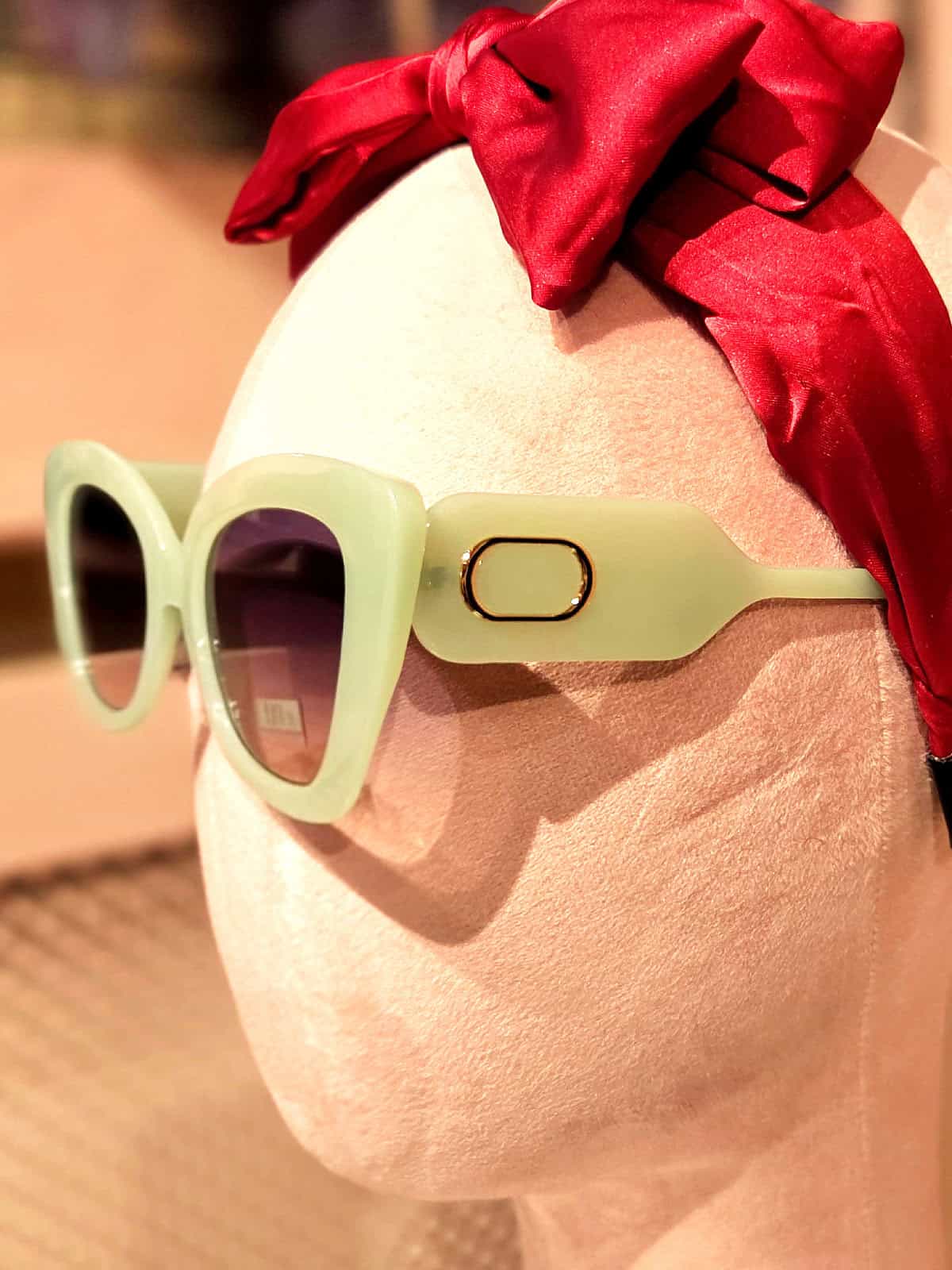 Solbriller med grøn indramning og mørke linser, perfekt til sommeren.