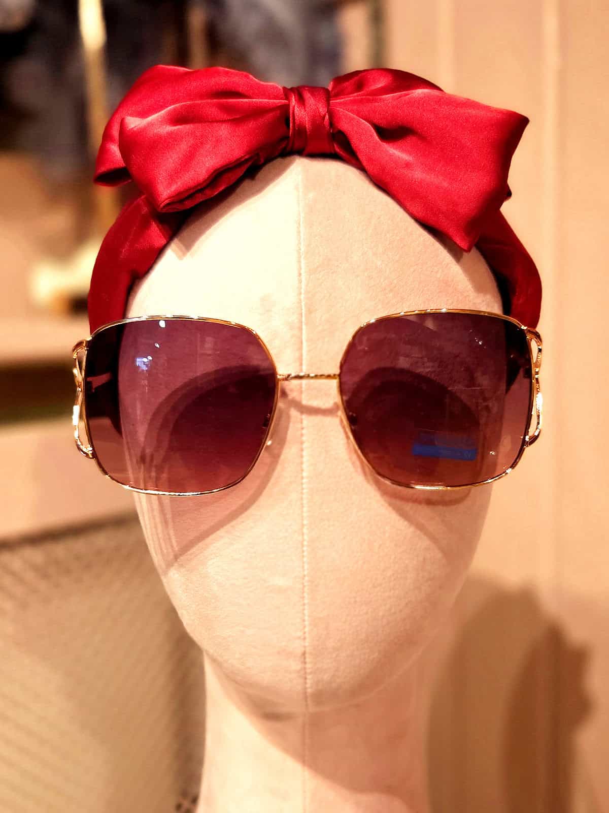 Solbriller med gyldne rammer og mørke glas til sommerbrug.