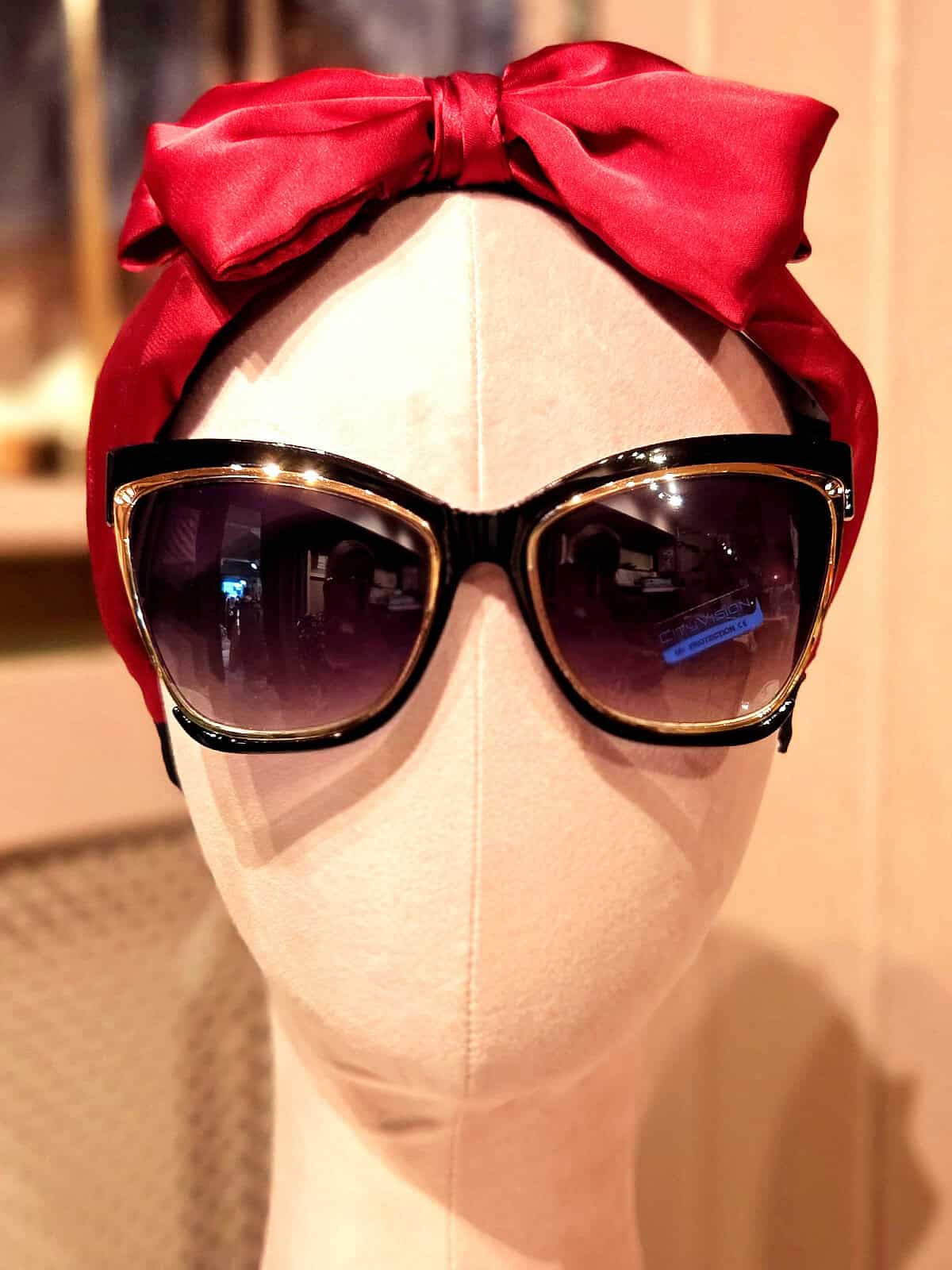 Solbriller med sort ramme og store mørke glas, perfekt til sommer og solrige dage.