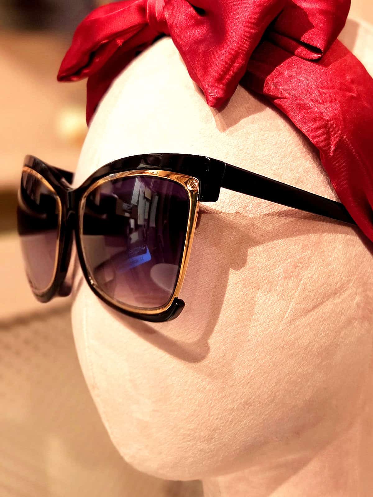 Solbriller med sort og guld ramme, perfekt til sommeren.