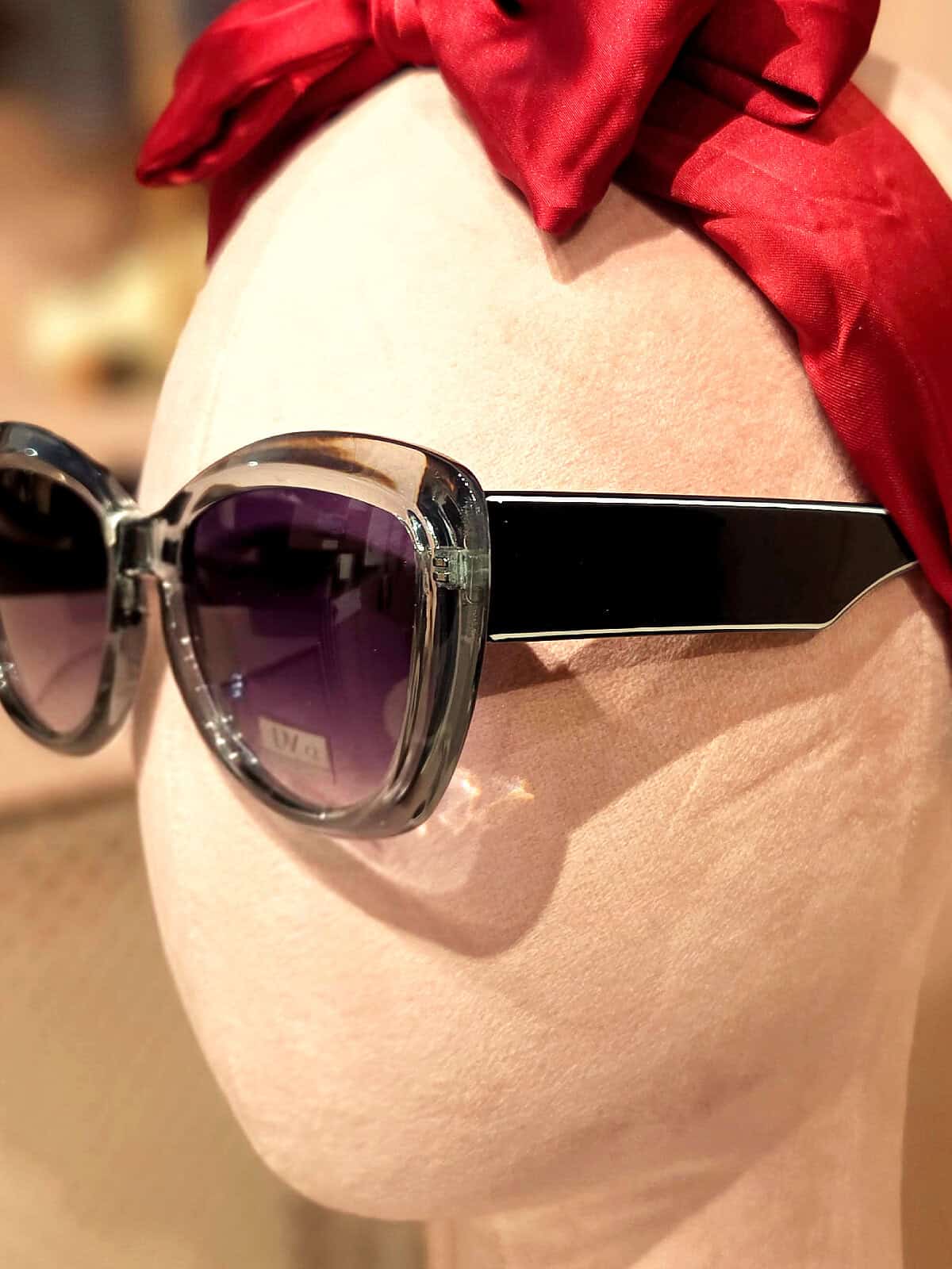 Solbriller med sort ramme og mørke linser, perfekt til sommeren.