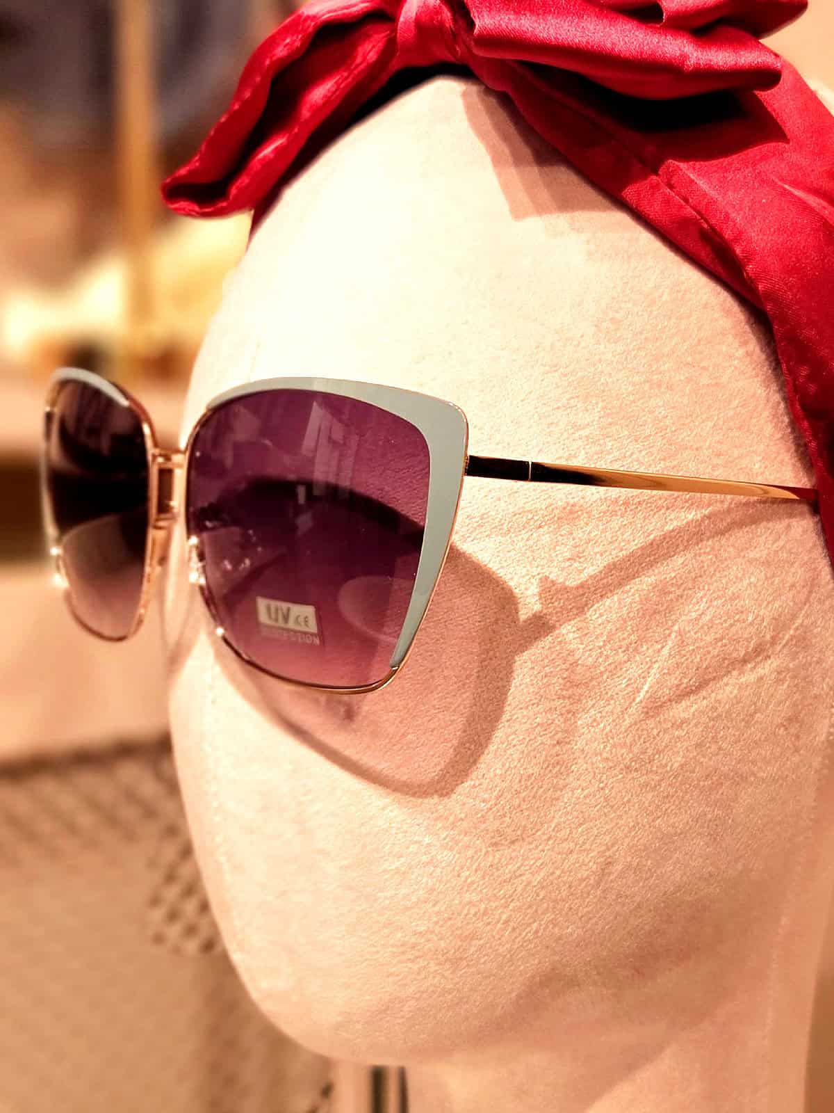 Solbriller med store, firkantede linser og gyldne stel. Perfekt til sommer og solrige dage.