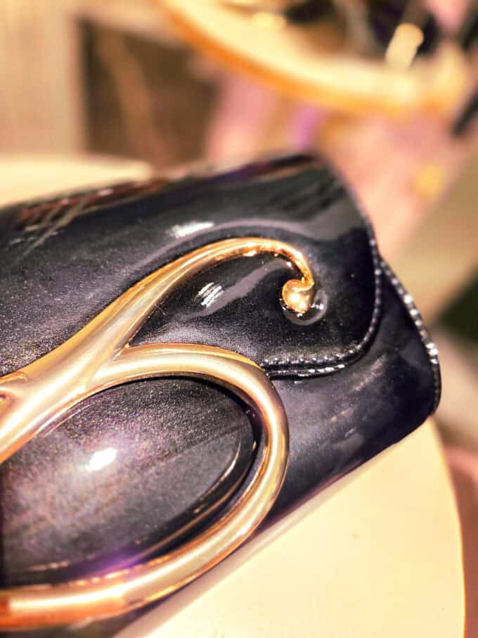 Sort lakclutch med guldlukning, elegant accessories til fest.