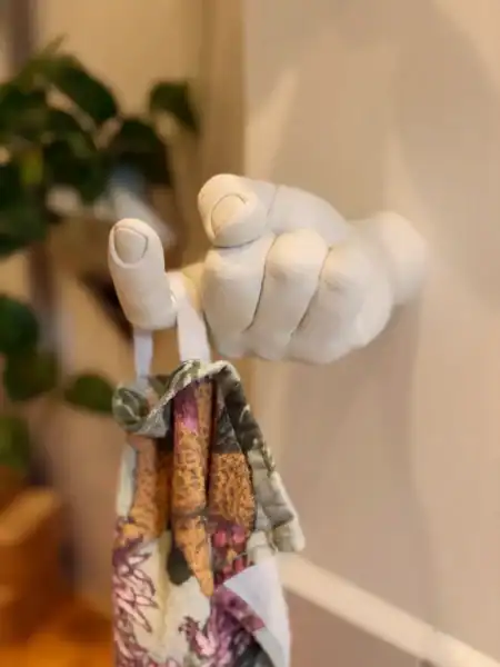 Håndlavet vægkrog i form af en hånd med offermotiv, perfekt til dekorative formål.