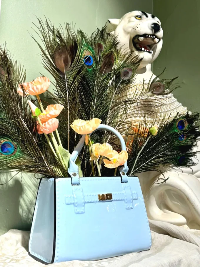 keramisk vase formet som håndtaske stylet med påfuglefjer