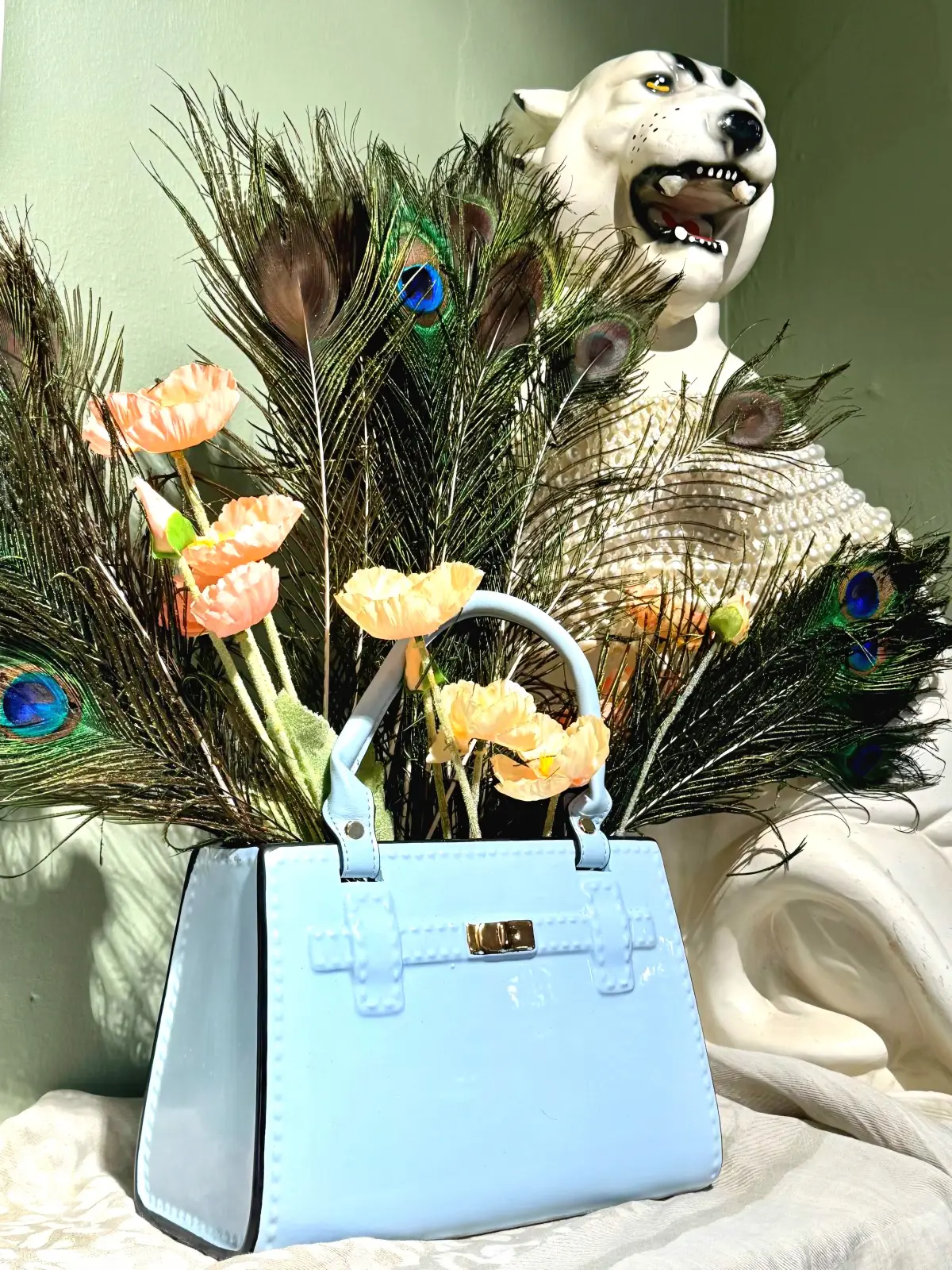 keramisk vase formet som håndtaske stylet med påfuglefjer