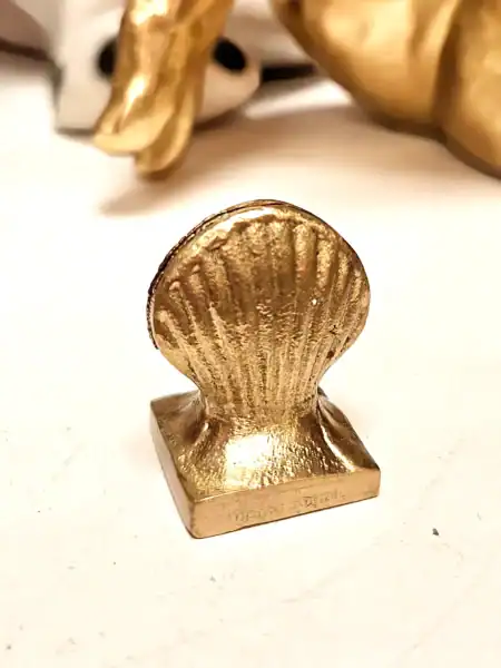 Elegant guld kortholder i form af en muslingeskal.