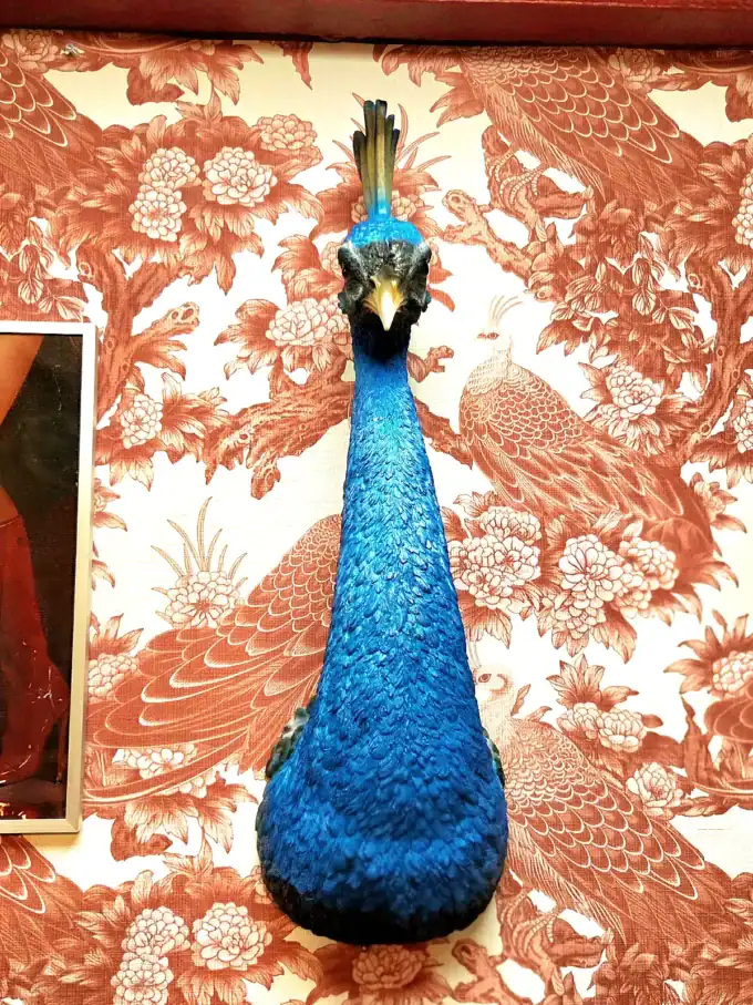 Peacock-figur i blå og guld til dekoration.