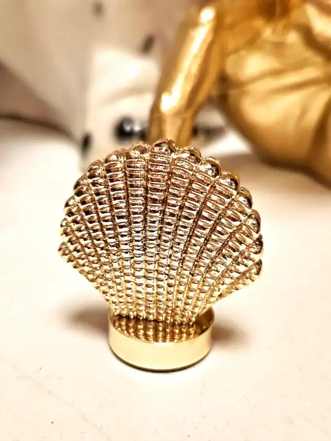 Guld shell kortholder som tilbehør, perfekt til elegante og unikke opbevaringsløsninger.