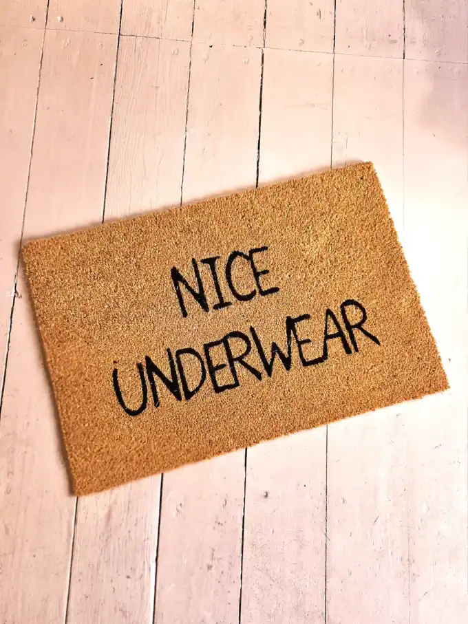 Kokosmåtte med teksten "Nice Underwear" til indgangsdøren.