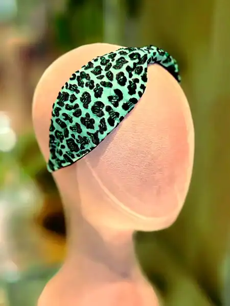 Hårbøjle med leopardmønster i grøn og sort, perfekt til festaccessories.