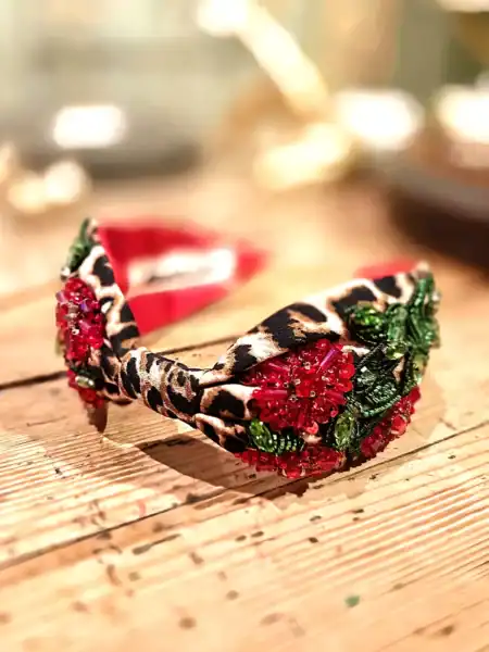 Hårbånd med blomsterdetaljer og leopardmønster, perfekt til fest eller hverdagsbrug.