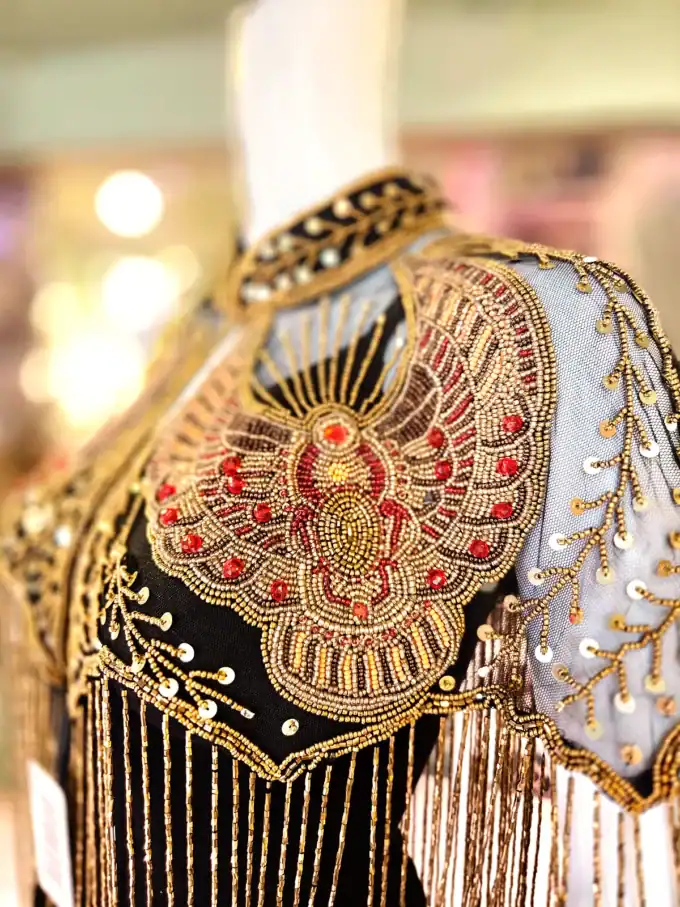 Perlekappe i sort og sølv med store, glitrende sten og detaljeret design.