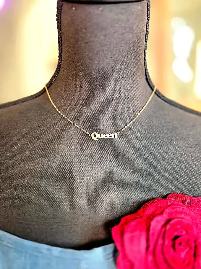 Elegant "Queen" halskæde på sort mannequin, perfekt til stilfulde outfits.