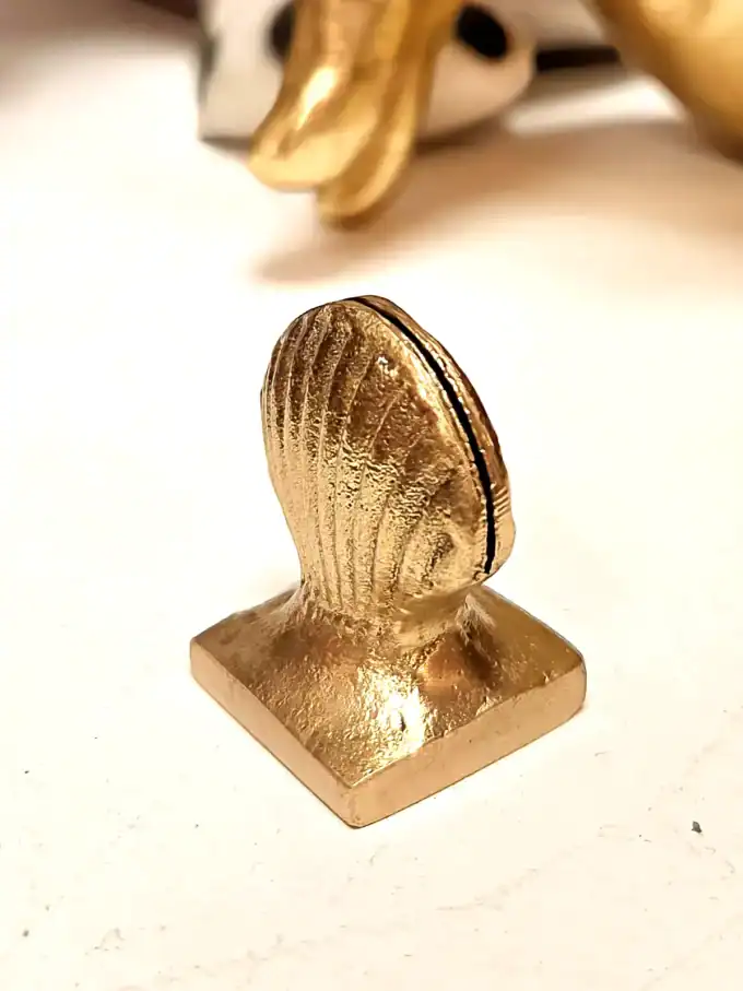 Elegant guld kortholder i form af en skaller, perfekt til kortopbevaring.