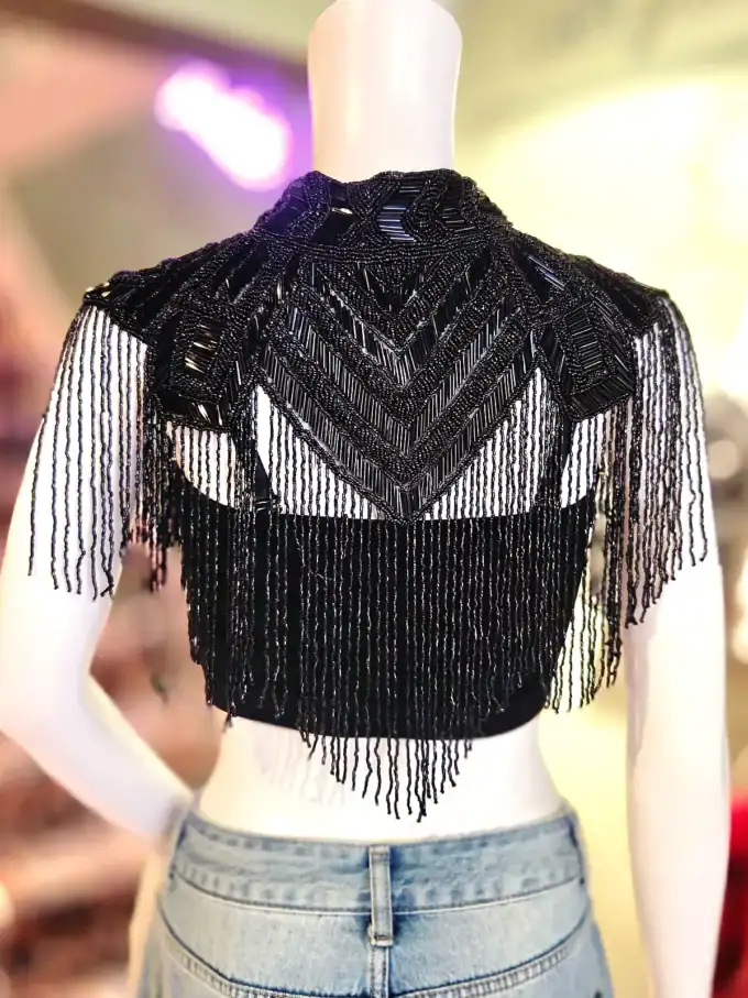 Elegant sort skulderkappe med frynser og unikt geometrisk mønster.