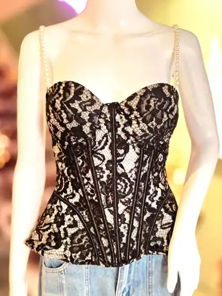 Elegant sort blonde top med perlespænder og bælte, perfekt til festlige anledninger.