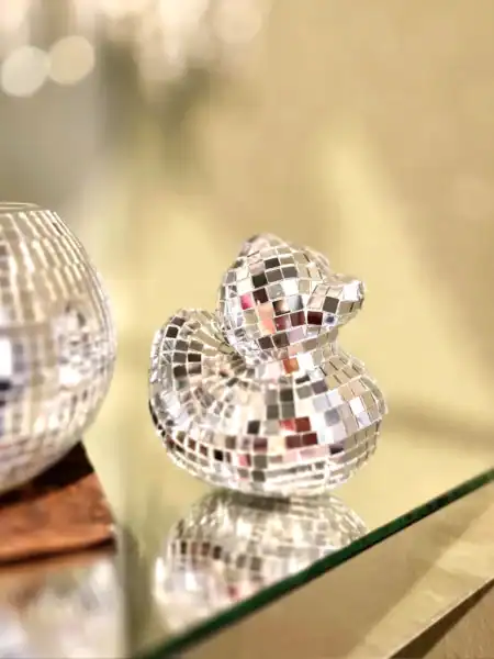 Reflekterende duck figur i spejlende mosaikmateriale.