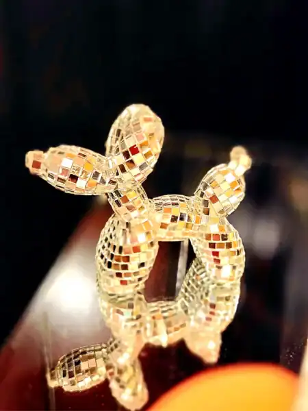 Gullfarvet bling hund i mosaikstil med refleksion på overfladen.