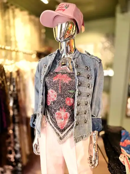 Moderne mannequin med denimjakke, pink cap og blomsterprint top.