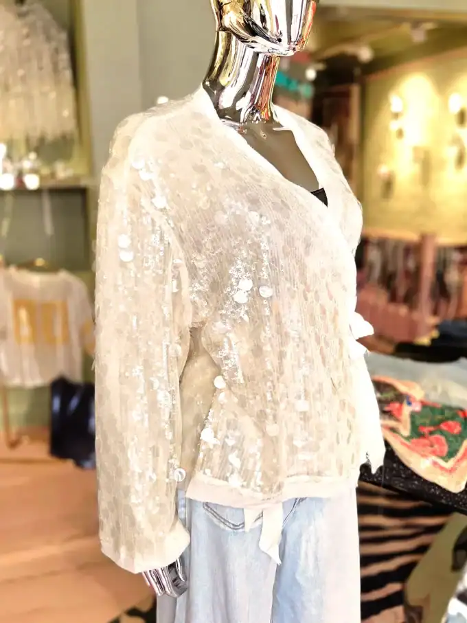Elegant slå-om cardigan med pailletter til festlige anledninger.
